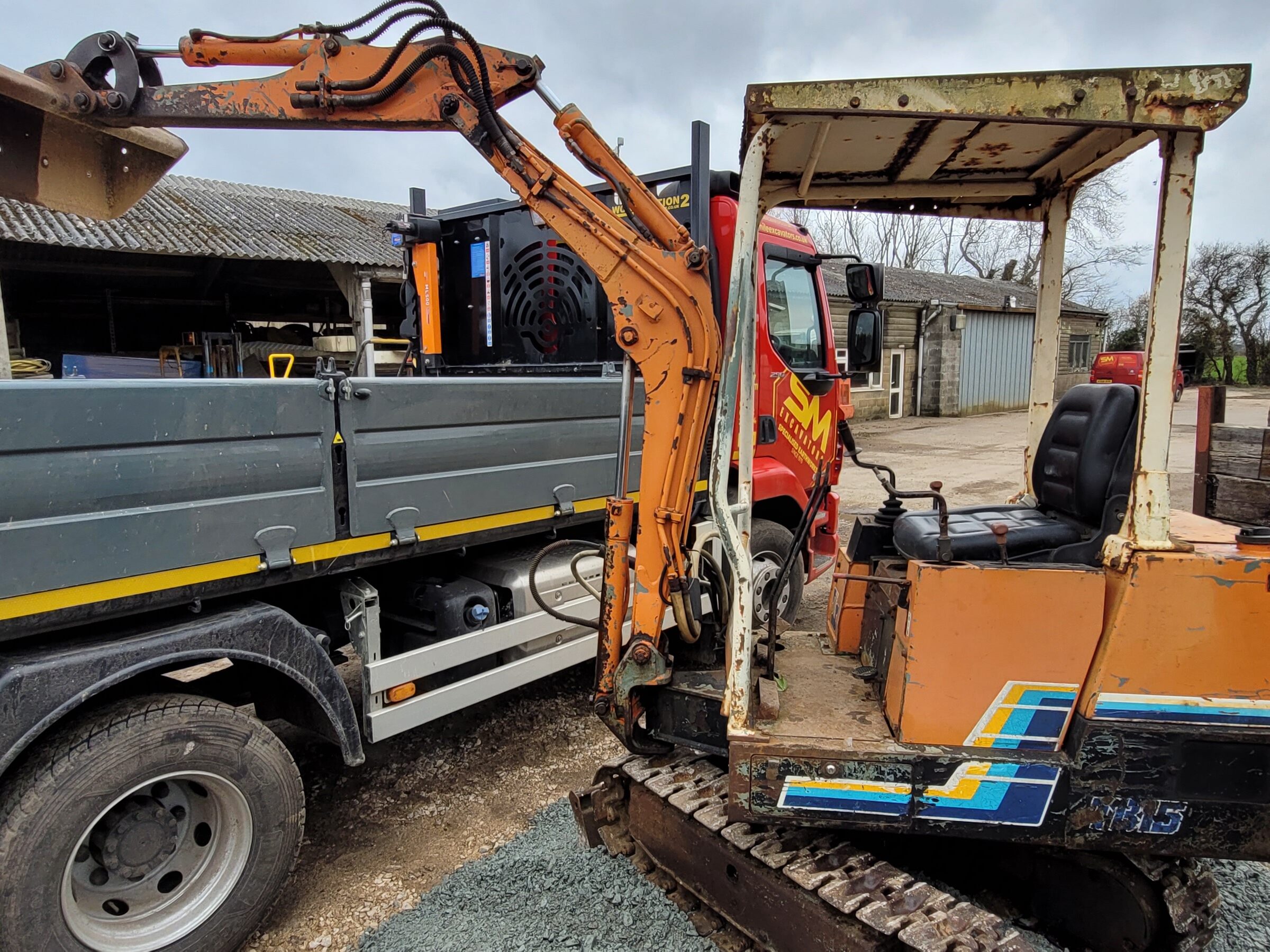 Takeuchi mini digger pouring into back of a wagon owned by six mile excavators 