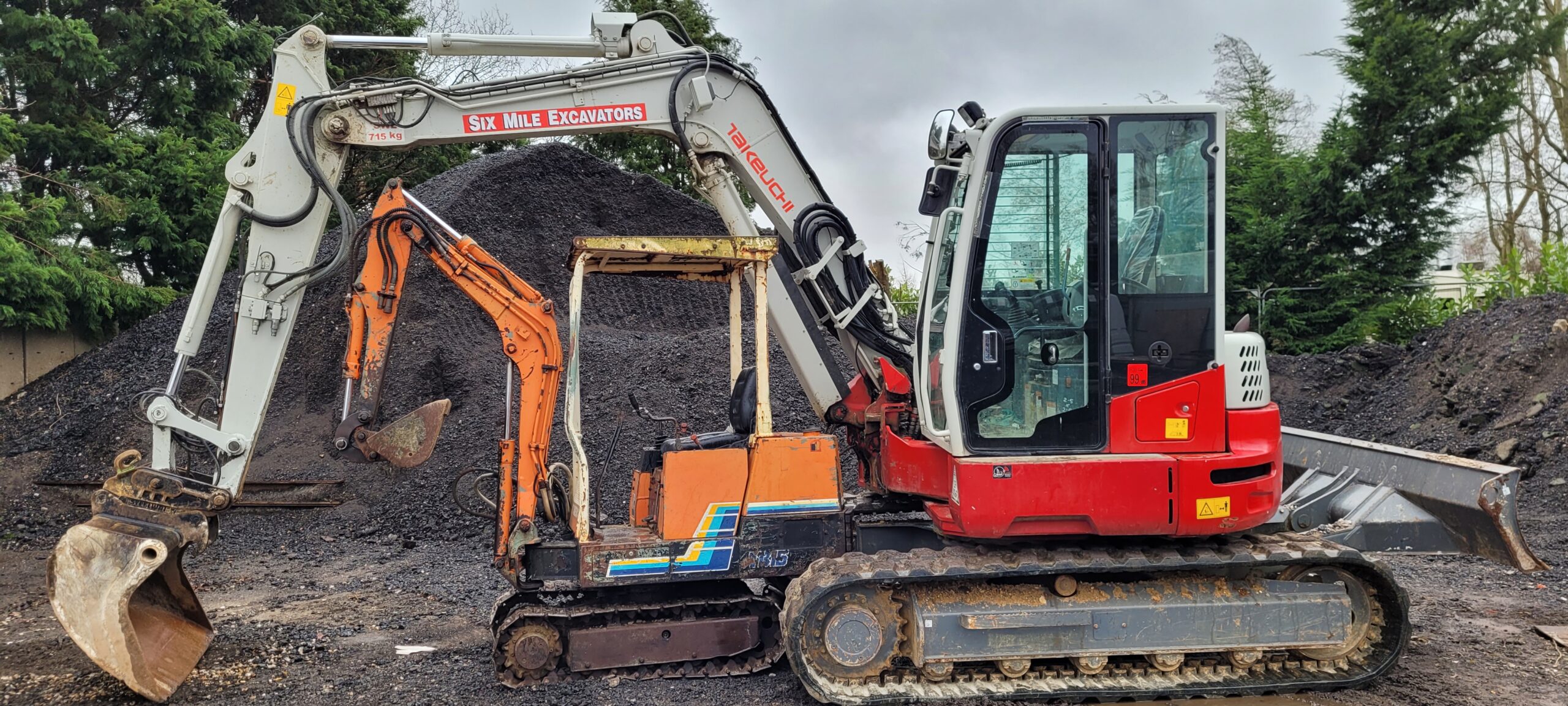 a new takeuchi excavator machine parked right behind an old takeuchi digger 