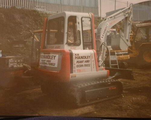 Old Takeuchi Digger parked up in yard with handley plant hire written down the side