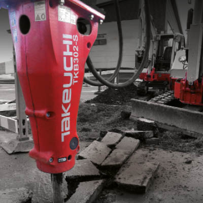a takeuchi hydraulic breaker used as an attachment on a digger. it has been breaking up the ground.
