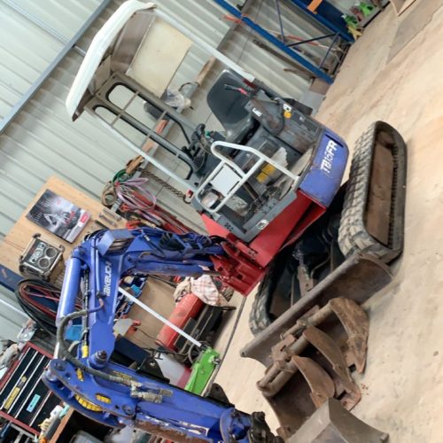 TB15FR Takeuchi digger fron 2001 in a warehouse with boom painted blue around some old machinery