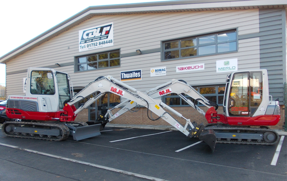 two takeuchi diggers parked up facing eachother. Each excavator has their boom crossing and parked in front of CBL Saltash Building