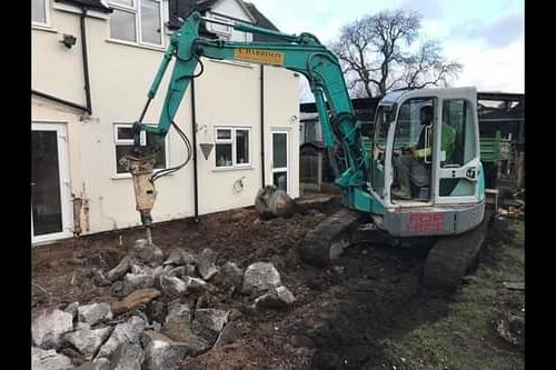 Takeuchi Digger breaking up groundworks outside of a house