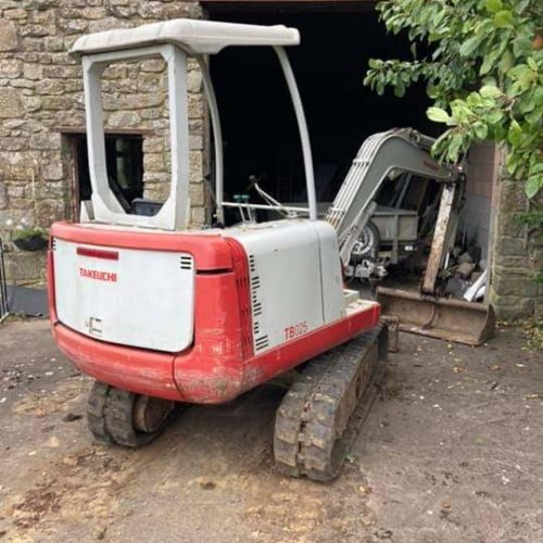 TB025 parked up outside open building with boom down