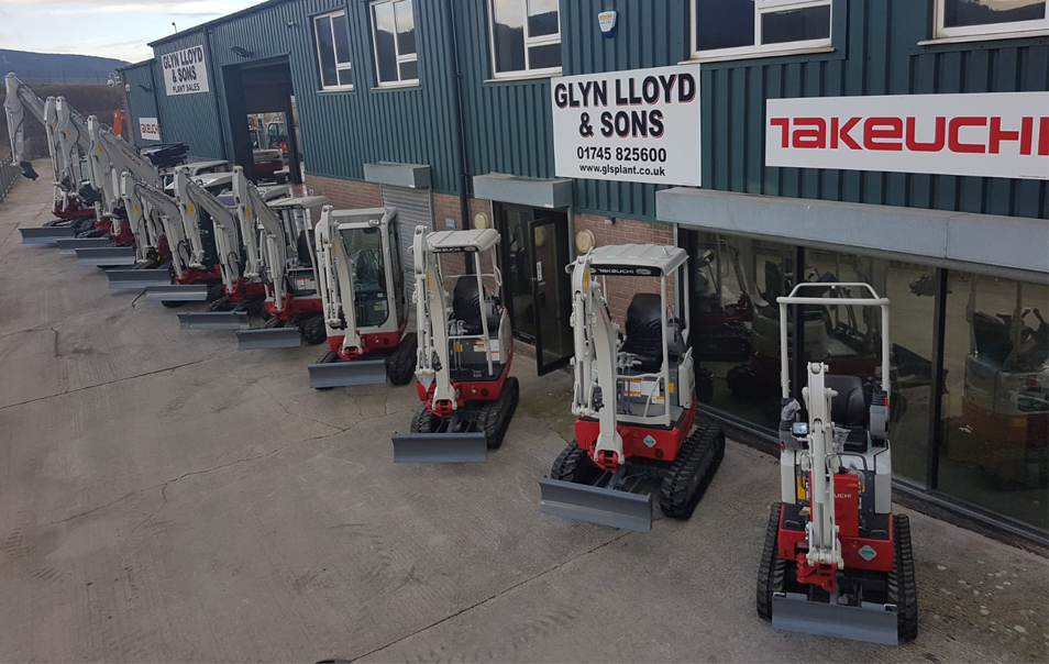 a line up of takeuchi diggers parked up in front of Glyn Lloyd & Sons building