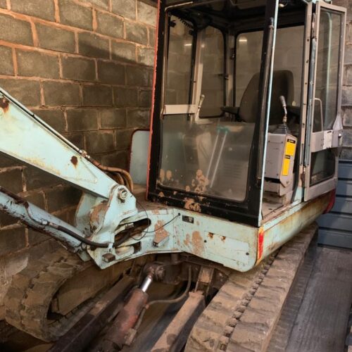 blue takeuchi digger parked in shed