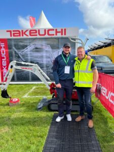 operator stood with dave vickers in front of takeuchi digger