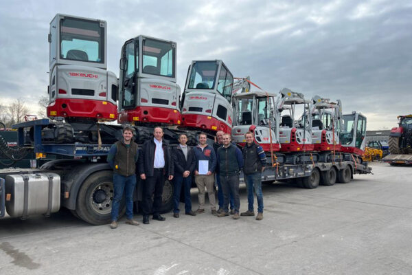 mcleans line up in front of takeuchi excavators on a wagon