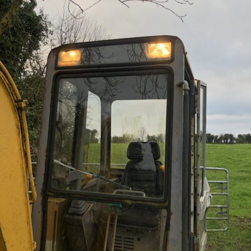 yellow takeuchi digger with lights on