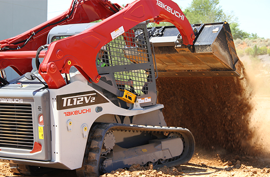 tracked loader tipping dirt out