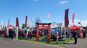 takeuchi stand with blue sky above. diggers on stand.