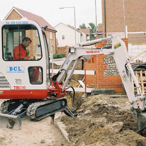 Takeuchi TB016 micro digger using boom to dig a hole for housebuilding construction site 1