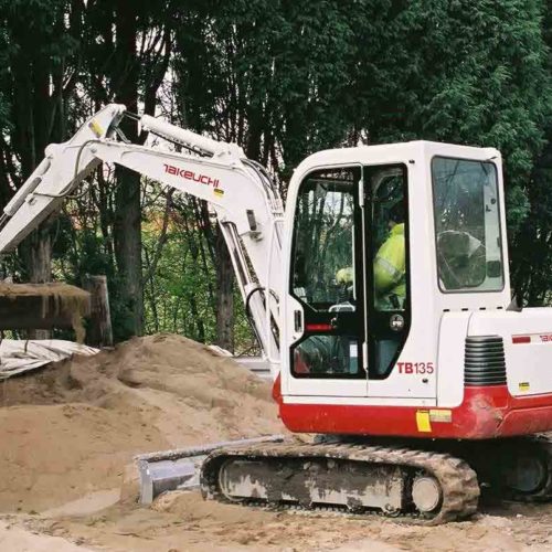 Takeuchi TB135 digger at Sale Golf Club picking up a bucket of sand